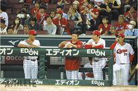 <div class="caption"> マツダ スタジアムのベンチでデータを確認する白濱スコアラー</div>