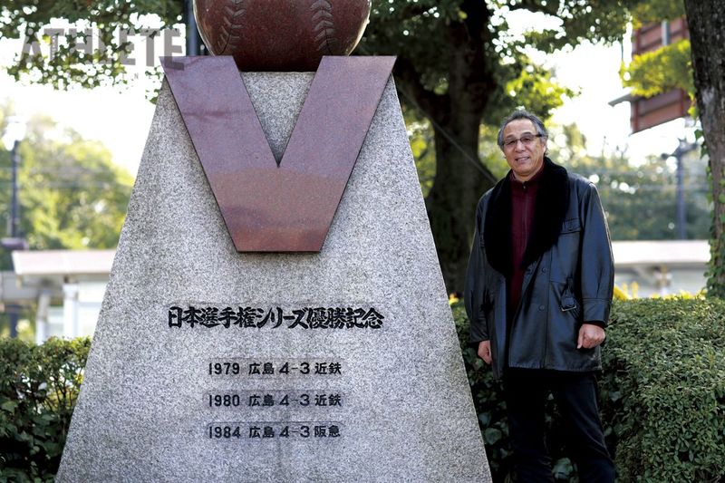 <div class="caption">旧広島市民球場跡地に設置された「日本選手権シリーズ優勝記念碑」の横で笑顔を見せる山根和夫氏（2015年撮影）</div>